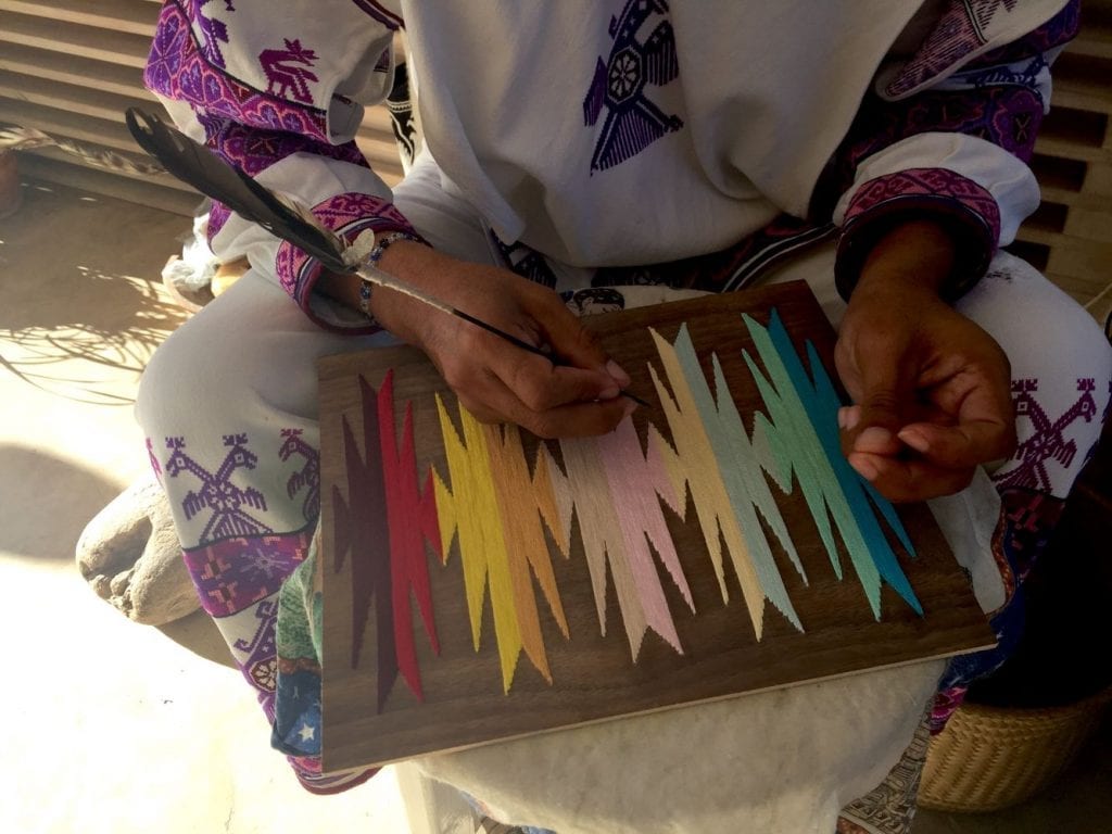 Mexican lady creating a traditional work of art