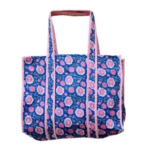 A handcrafted shopping tote with a blue fabric cover, featuring a repeating pattern of pink floral embroidery with green vines and leaves, accented by red and white striped borders and handles, set against a plain white background.