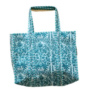 A handcrafted shopping tote with a white fabric cover, featuring an intricate teal floral and vine embroidery pattern, accented by teal and white striped borders and handles, set against a plain white background.