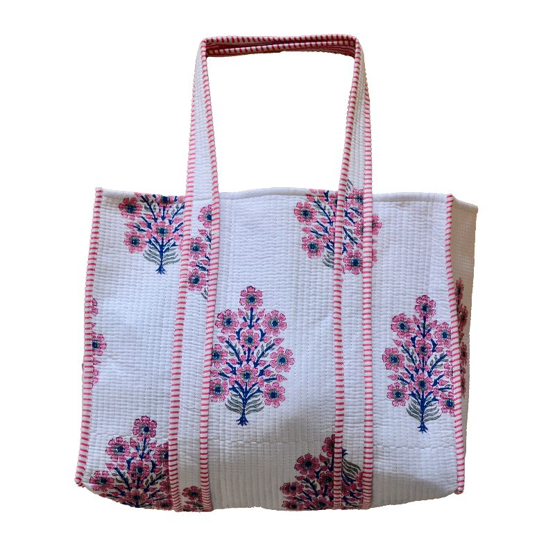 A handcrafted bag with a white fabric cover, featuring intricate pink and blue floral embroidery patterns, accented by red and white striped borders and handles, set against a plain white background.