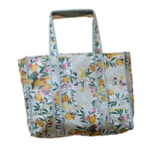 handcrafted shopping tote features a hand-block printed pattern of white cockatoos, yellow pomegranates, and green and pink floral branches on a white background.