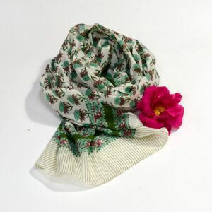 Hand block printed on organic cotton scarf with a mustard yellow base, intricate red and green floral patterns, subtle geometric shapes, and a black-and-white accented border, showcasing traditional craftsmanship for a stylish, eco-friendly accessory.