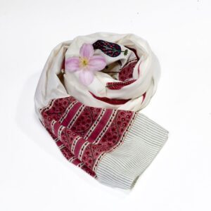 Hand block printed on organic cotton scarf with a rich mustard yellow base, intricate red and teal floral patterns, delicate vine motifs, and a decorative geometric border, showcasing traditional techniques and natural dyes for a vibrant, eco-friendly accessory.