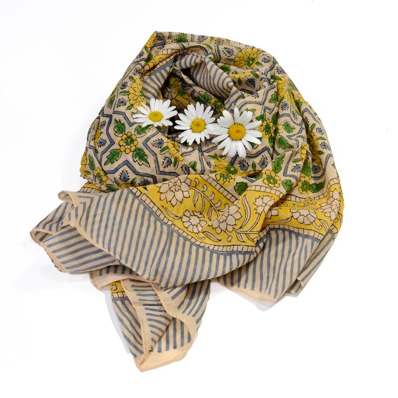 Hand block printed on organic cotton Pareo Beach Sarong with a creamy yellow base, intricate floral patterns in yellow, green, and blue within geometric frames, and a blue-and-white striped border, showcasing traditional craftsmanship for a vibrant, eco-friendly beach accessory.