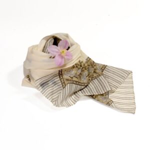 Hand block printed on organic cotton scarf with a beige and cream base, intricate brown floral patterns, leaf motifs, vine designs, and a symmetrical striped border, showcasing traditional hand-stitched embroidery and natural dyes for a sophisticated, eco-friendly accessory.
