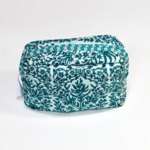 A handcrafted cosmetics bag with a light teal fabric cover, featuring an intricate teal floral and vine embroidery pattern, accented by a teal and white striped border and a white tassel, set against a plain white background.