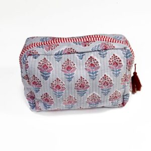 This handcrafted cosmetics bag features a soft grey fabric cover adorned with a repeating pattern of vibrant red and blue floral motifs, each design showcasing intricate, detailed petals and leaves.
