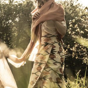 woman wears cream and terracotta wrap skirt in a sun-drenched meadow