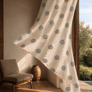 Breezy Mediterranean living room with Ocean Blue medallion block printed linen curtain hanging beside a sunlit terrace.
