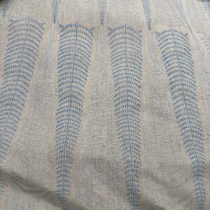 Close-up swatch of Indigo Fern hand block printed linen fabric featuring blue vertical leaf patterns on unbleached linen.